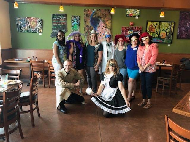The dental team and family of Georgia Knotek DDS standing together in a restaurant dressed for a Halloween party in Greenfield, IN